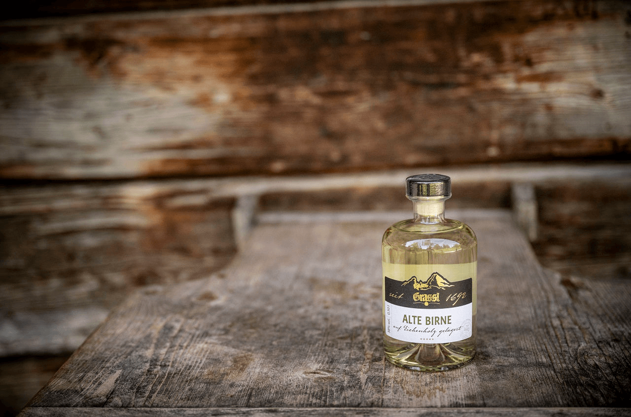 Alte Birne auf einem Holztisch mit einer Hütte im Hintergrund.